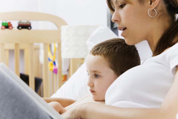 mother teaching child on computer